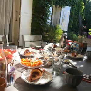 uma mesa com pratos de comida em cima em Chambres d'Hôtes et Gîtes Le Mas Mellou em Orange