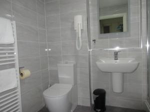 a bathroom with a toilet and a sink at Simpson's Apartments Rugby Ltd in Rugby