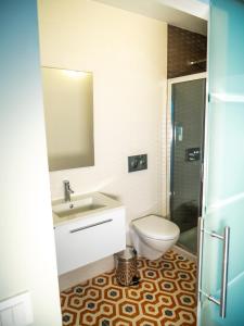 a bathroom with a toilet and a sink and a shower at Guest House Stories in Beja