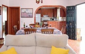 uma sala de estar com um sofá e uma mesa com cadeiras em Casa Rural Torrox - Cortijo Latero em Torrox