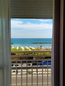 ein Fenster mit Blick auf den Strand von einem Resort in der Unterkunft Hotel Ristorante Miramare in Pesaro