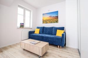 a living room with a blue couch and a coffee table at Apartamenty City Center Cicha 8 in Krynica Zdrój