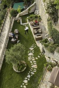 - une vue sur le jardin avec des personnes assises sur des bancs dans l'établissement Albergo Diffuso Sotto Le Stelle, à Picinisco