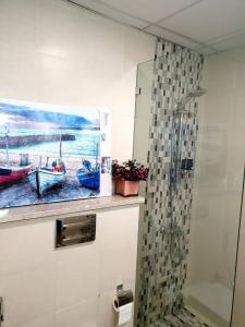 a bathroom with a painting of boats on the wall at Melsky Apartment Dubai in Dubai