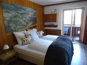 a bedroom with a bed with white sheets and a window at Appartementhaus Mayrhofen by PiaundDirk in Mayrhofen