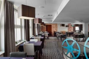 a restaurant with tables and chairs in a room at Focus Hotel Premium Elbląg in Elblag