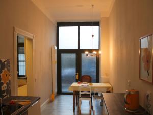 eine Küche und ein Esszimmer mit einem Tisch und einem Fenster in der Unterkunft aTa & oMo in Köln