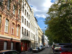una calle de la ciudad con edificios y coches aparcados en la calle en aTa & oMo, en Colonia