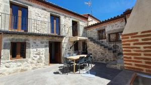 a patio with a table and chairs in a building at Casas del Castillo, 1 in Ávila