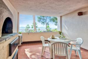 a dining room with a table and chairs and a large window at Résidence Pierre & Vacances Louis Lumière in Bandol