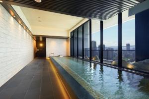 a swimming pool in the middle of a building with windows at MGH Mitsui Garden Hotel Taipei Zhongxiao in Taipei