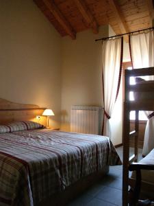 Rifugio Campiglio في Dumenza: غرفة نوم بسرير ونافذة