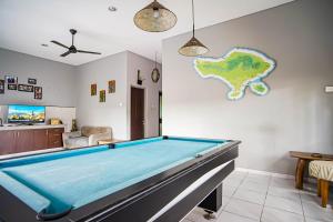 a pool table in a living room with a map on the wall at DD Living in Canggu