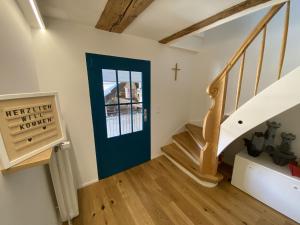 un escalier avec une porte bleue et une croix sur le mur dans l'établissement Traumhaft wohnen im Haus Blum, à Herbolzheim