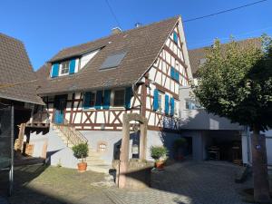 een oud gebouw met blauwe luiken en een huis bij Traumhaft wohnen im Haus Blum in Herbolzheim