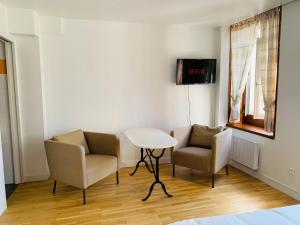 a room with two chairs and a table and a tv at Le cottage des remparts - face hotel de ville in Boulogne-sur-Mer