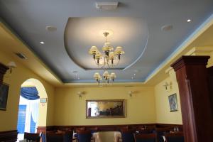 una sala da pranzo con soffitto e lampadario pendente di Hotel Adria a Kaštela (Castelli)