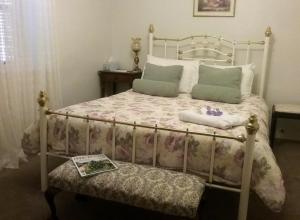 Un dormitorio con una cama y un libro en un banco en Walnut Cottage, en Angaston