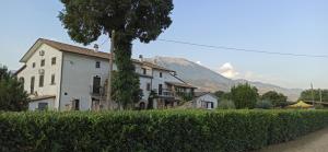 una grande casa bianca con una montagna sullo sfondo di B&B La Staffa ad Aquino