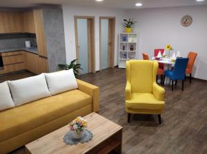 a living room with a couch and chairs and a table at Shiny Apartmán in Spišská Nová Ves