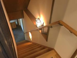 an overhead view of a stairway with a light at Roman Kan in Kyoto