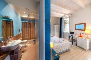 a bathroom with a sink and a bed in a room at Hotel La Villa Del Mare in Cagliari