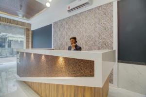 a man talking on a cell phone behind a counter at Hotel Palm Beach Pride in Mumbai