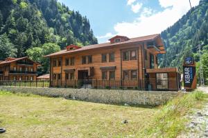 a large wooden house in the middle of a mountain at Kibar Suite Hotel in Uzungol