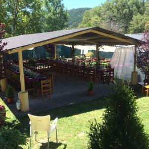 a pavilion with chairs and tables in a garden at Resort Camping Solopuent in Castiello de Jaca