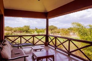 un porche cubierto con vistas a la sabana en Ol-Kine Cottage at The Great Rift Valley Lodge & Golf Resort Naivasha en Naivasha