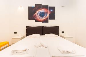 una camera da letto con un letto bianco con tre dipinti sul muro di Mole Antonelliana & Royal Gardens Cozy Studio a Torino