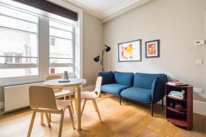 a living room with a blue couch and a table at Hausd Flex - Covent Garden in London