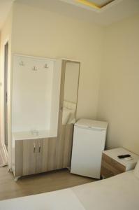 a white bathroom with a sink and a refrigerator at Kemer Suites in Kemer