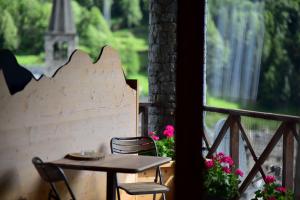 a table and chairs on a balcony with a window at MH Olen Boutique Hotel in Alagna Valsesia