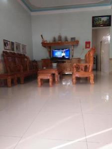 a living room with a tv and a table and chairs at Hải Phận Homestay in Ha Giang