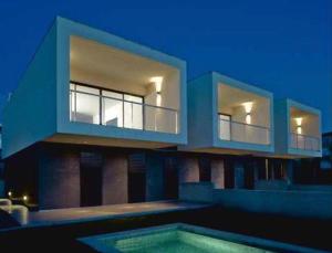 uma casa com uma piscina em frente em Luxus Chalet Casas Blancas em Cala Mendia