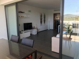 a living room with a table and chairs and a television at Luxus-Chalet-Casas-Blancas-cases-blanques-1-casa-A in Cala Mendia