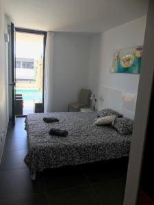 1 dormitorio con cama y ventana grande en Luxus Chalet Casas Blancas, en Cala Mendia
