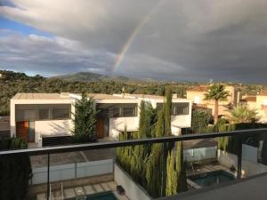 a rainbow over a house with trees at Luxus-Chalet-Casas-Blancas-cases-blanques-1-casa-A in Cala Mendia