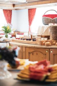 a kitchen with a counter with plates of food at Hotel Chalet Corso in San Vigilio Di Marebbe