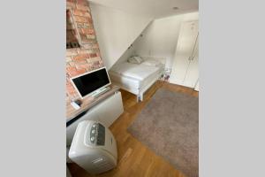 una pequeña sala de estar con sofá y TV en DG Wohnung mit separatem Eingang nahe Düsseldorf en Meerbusch