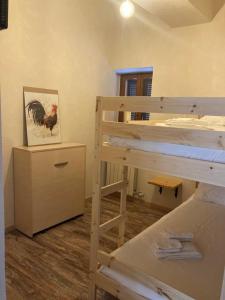 a bedroom with a bunk bed with aoster on the wall at Locanda Il Gallo in Baveno