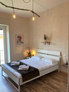 1 dormitorio con 1 cama grande y 2 toallas. en Locanda Il Gallo, en Baveno