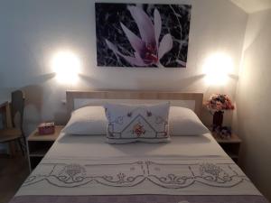 ein Schlafzimmer mit einem Bett mit einem Kissen darauf in der Unterkunft Apartments City Paradise in Mostar
