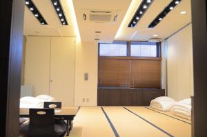 a room with a table and chairs and a window at My Hotel Ryugu in Shizuoka