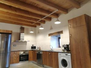 a kitchen with a dishwasher and a washer at Cal Teixidor - La Fusteria in Salo