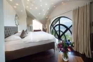 a bedroom with a large bed and a large window at Hotel Uto Kulm - autofrei in Zurich