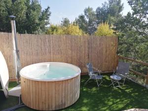 bañera de hidromasaje en un patio con 2 sillas en Cal Teixidor - La Fusteria en Salo