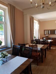 a dining room with tables and chairs and a window at Hotel Penterknapp in Bramsche