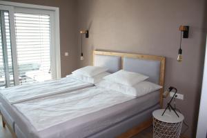 a bedroom with a large white bed with a window at Top 20 Alpe Maritima - Ferienapartment Alps & Lake in Annenheim